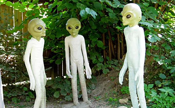 Tre utklädda personer med gröna alienhuvuden. Foto.